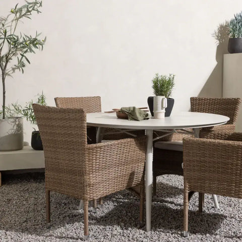 Rundt marmorbord og minimalistiske træstole i nordisk design.