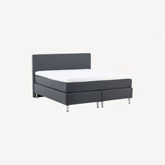 Sovesofa i gråt stof med træben - praktisk møbel til soveværelset eller gæsteværelset.